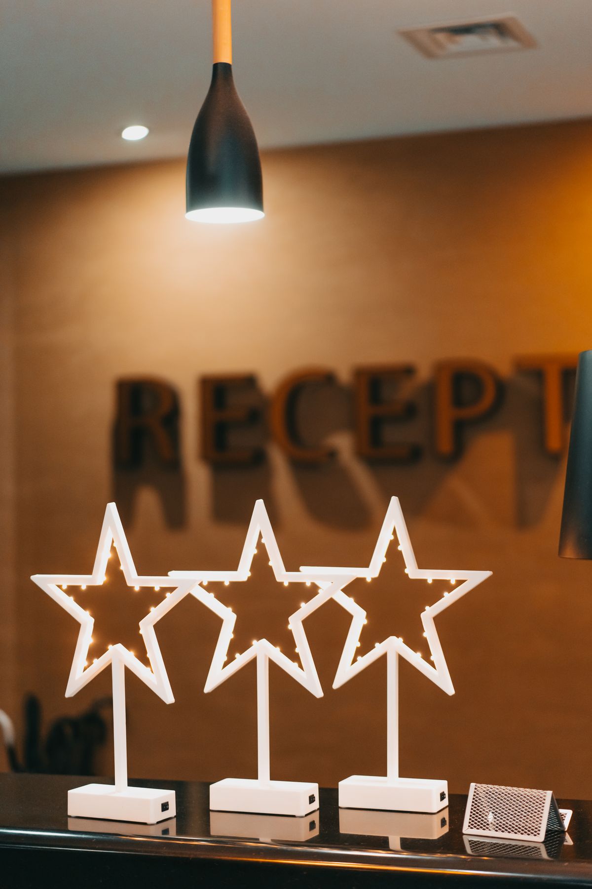 Three illuminated star decorations on a reception desk